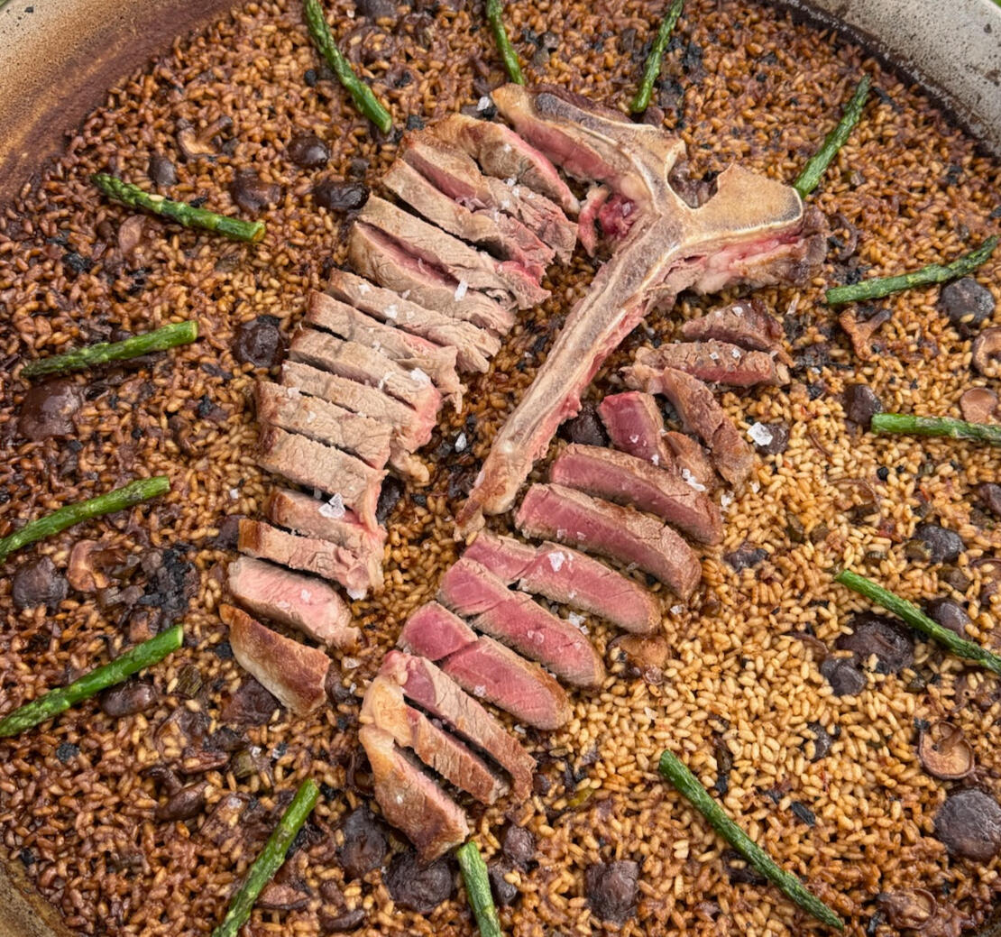 Texas Style Paella – The Gourmet Paella Texas-style paella with grass-fed ribeye, shiitake mushrooms, and fresh asparagus – a bold fusion of Spanish tradition and Texas flavors